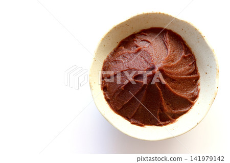 Smooth bean paste viewed from directly above against a white background. Smooth bean paste viewed from directly above against a white background. 141979142