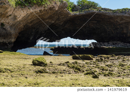 A tunnel-shaped rocky outcrop on the coast with a clear view of the horizon. A tunnel-shaped rocky outcrop on the coast with a clear view of the horizon. 141979619