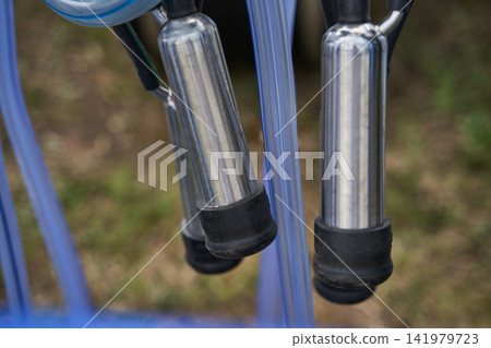 Bicycle Pedals Hanging From Blue Frame Outdoors In Close-Up Against Blurred Ground Background Bicycle Pedals Hanging From Blue Frame Outdoors In Close-Up Against Blurred Ground Background 141979723