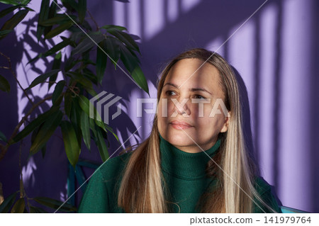 Middle-Aged Woman Gazing While Seated With Sunlight Striped Shadows On Face And Hair In Indoor Middle-Aged Woman Gazing While Seated With Sunlight Striped Shadows On Face And Hair In Indoor 141979764