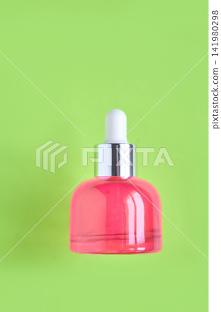 Pink Glass Dropper Bottle Standing Upright On Lime Green Backdrop In Studio Composition With Silver Pink Glass Dropper Bottle Standing Upright On Lime Green Backdrop In Studio Composition With Silver 141980298