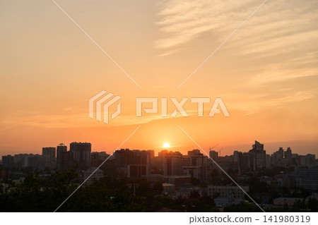 Sunset Skyline Silhouetted Above Urban Buildings Under Orange Evening Sky Sunset Skyline Silhouetted Above Urban Buildings Under Orange Evening Sky 141980319