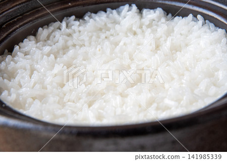 Shiny, glossy rice cooked in an earthenware pot Shiny, glossy rice cooked in an earthenware pot 141985339