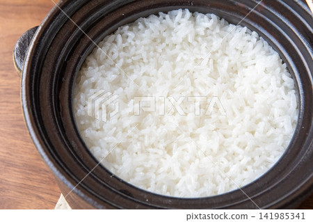 Shiny, glossy rice cooked in an earthenware pot Shiny, glossy rice cooked in an earthenware pot 141985341