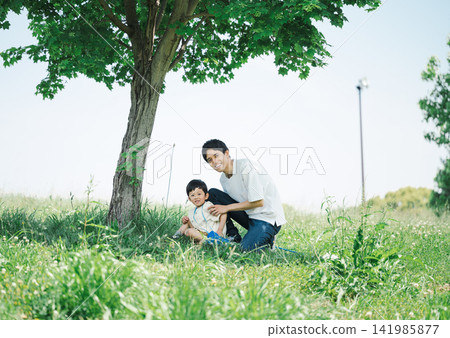 Dad and son playing in the park on a holiday Dad and son playing in the park on a holiday 141985877