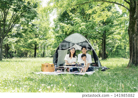 A family enjoying the outdoors in the park on their day off. A family enjoying the outdoors in the park on their day off. 141985882