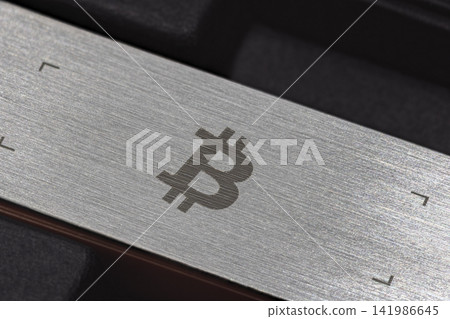 Close-up of Brushed Metal Surface with Bitcoin Symbol Close-up of Brushed Metal Surface with Bitcoin Symbol 141986645