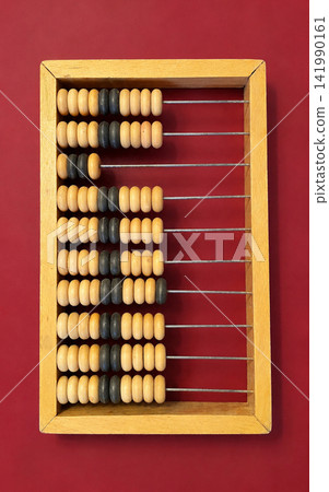 Wooden Abacus for Counting and Arithmetic on Red Background Wooden Abacus for Counting and Arithmetic on Red Background 141990161