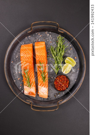 Raw salmon fillets preparing with rosemary and lime Raw salmon fillets preparing with rosemary and lime 141992433