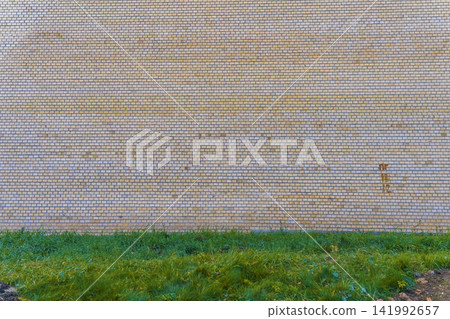brick wall stationary outdoors neutral ground level grass concrete architecture urban yellow green. brick wall stationary outdoors neutral ground level grass concrete architecture urban yellow green. 141992657