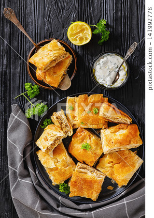 Crispy phyllo ground meat pie cut into squares Crispy phyllo ground meat pie cut into squares 141992778