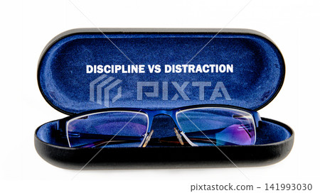 A pair of glasses is placed inside a black case that shows the words discipline vs distraction. The case is open and focused on the glasses A pair of glasses is placed inside a black case that shows the words discipline vs distraction. The case is open and focused on the glasses 141993030