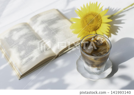 Summer iced coffee with sunflowers and a book Summer iced coffee with sunflowers and a book 141993140