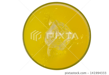 Top view of yellow carbonated soft drink with ice cube in a glass Top view of yellow carbonated soft drink with ice cube in a glass 141994333