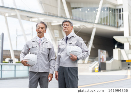 身穿工作服的老者手持頭盔 身穿工作服的老者手持頭盔 141994866