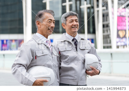 身穿工作服的老者手持頭盔 身穿工作服的老者手持頭盔 141994873
