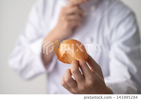The chef peels the onion. 141995284
