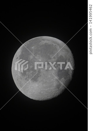 Full moon glows against pure black sky. Surface details visible in crisp grayscale tones. Crisp lunar features stand out clearly. Natural lunar texture captured with high clarity 141995462