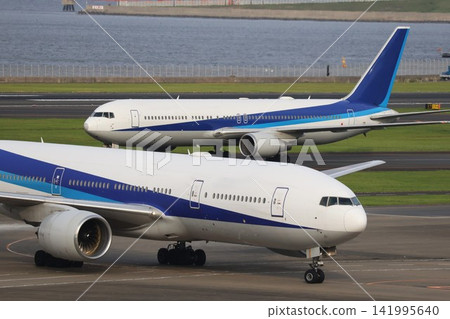 Two airplanes taxiing on the taxiway at Haneda Airport. Two airplanes taxiing on the taxiway at Haneda Airport. 141995640