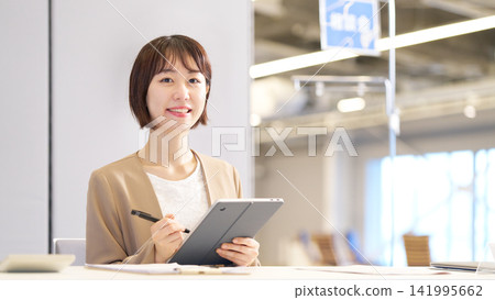A smiling female counselor holding a pen and tablet. A smiling female counselor holding a pen and tablet. 141995662