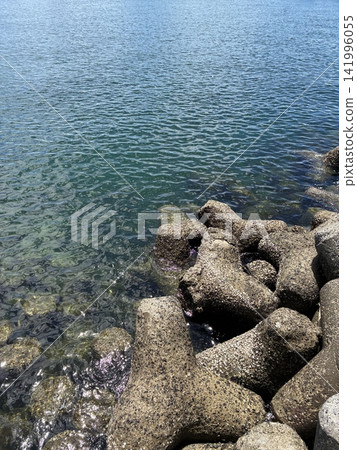 一張充滿夏日氣息的海岸照片,展現了晴朗夏日天空下波光粼粼的水面、港口的四腳架和防波堤(豎版)。 一張充滿夏日氣息的海岸照片,展現了晴朗夏日天空下波光粼粼的水面、港口的四腳架和防波堤(豎版)。 141996055