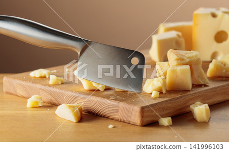 Parmesan cheese and knife on a cutting board. Parmesan cheese and knife on a cutting board. 141996103