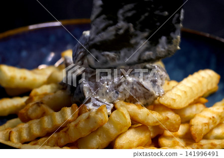 Culinary Presentation of Creamy Mushroom Sauce over Crinkle-Cut Fries for Gourmet Dining Culinary Presentation of Creamy Mushroom Sauce over Crinkle-Cut Fries for Gourmet Dining 141996491