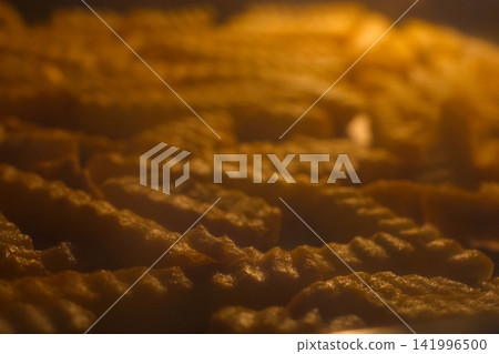 Golden Crinkle-Cut French Fries Baking in Oven - Perfect for Food and Snack Advertisements Golden Crinkle-Cut French Fries Baking in Oven - Perfect for Food and Snack Advertisements 141996500