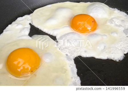 Sunny Side Up Breakfast: Perfectly Cooked Eggs in a Frying Pan Sunny Side Up Breakfast: Perfectly Cooked Eggs in a Frying Pan 141996559