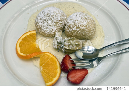 Delicious Dessert with Dumplings and Fresh Fruit Garnish on Creamy Sauce Delicious Dessert with Dumplings and Fresh Fruit Garnish on Creamy Sauce 141996641