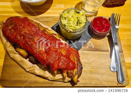 Rustic Dining Experience with BBQ Ribs and Cabbage Slaw on Wooden Board Rustic Dining Experience with BBQ Ribs and Cabbage Slaw on Wooden Board 141996726