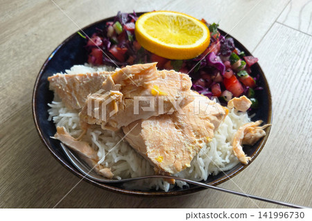 Healthy Meal with Salmon, Rice, and Fresh Vegetable Salad Garnished with Orange Slice Healthy Meal with Salmon, Rice, and Fresh Vegetable Salad Garnished with Orange Slice 141996730