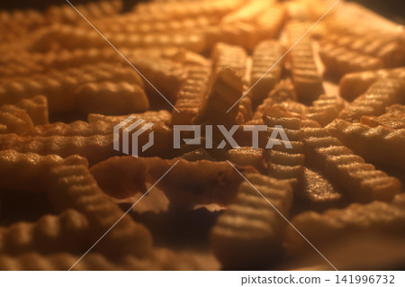 Golden Crinkle-Cut French Fries Under Warm Light - Perfect for Fast Food, Snack, or Comfort Food Design Golden Crinkle-Cut French Fries Under Warm Light - Perfect for Fast Food, Snack, or Comfort Food Design 141996732