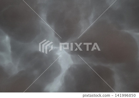 Stormy Sky with Dark Clouds Forming an Ominous Atmosphere for Weather-Themed Designs Stormy Sky with Dark Clouds Forming an Ominous Atmosphere for Weather-Themed Designs 141996850