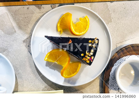 Decadent Chocolate Cake Slice with Orange Slices on a Modern Plate - Perfect for Culinary Art or Food Photography Decadent Chocolate Cake Slice with Orange Slices on a Modern Plate - Perfect for Culinary Art or Food Photography 141996860