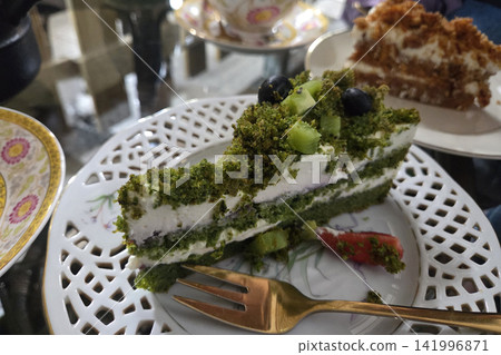 Delicious Green Matcha Cake with Fresh Kiwi and Blueberries on Decorative Plate 141996871