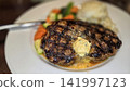 Grilled Ribeye Steak with Herb Butter, Mashed Potatoes and Roasted Vegetables on Plate 141997123