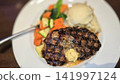 Grilled Ribeye Steak with Herb Butter, Mashed Potatoes and Roasted Vegetables on Plate 141997124