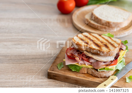 Grilled club sandwich with bacon and ham Grilled club sandwich with bacon and ham 141997325