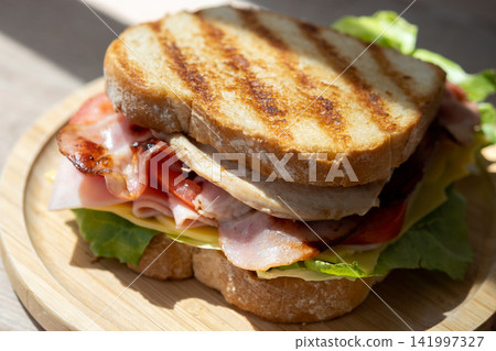 Grilled club sandwich with bacon and ham Grilled club sandwich with bacon and ham 141997327