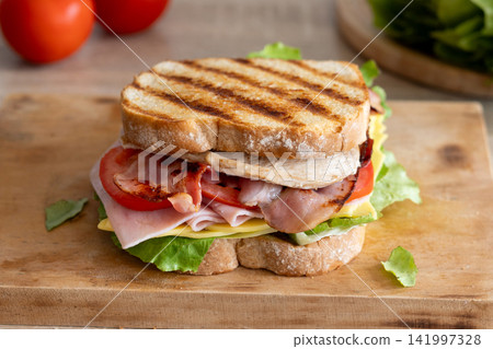 Grilled club sandwich with bacon and ham Grilled club sandwich with bacon and ham 141997328