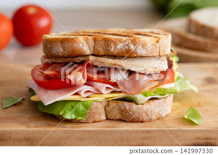 Grilled club sandwich with bacon and ham 141997330