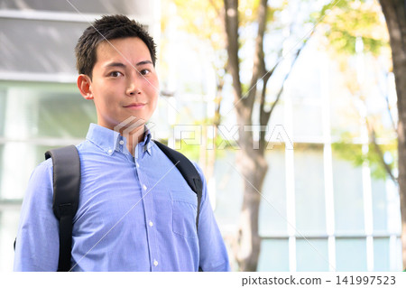 一名身穿藍色襯衫、背著背包的男子。 141997523
