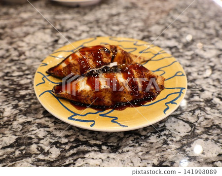 Conger eel nigiri sushi, two pieces with sweet sauce, at a conveyor belt sushi restaurant. Conger eel nigiri sushi, two pieces with sweet sauce, at a conveyor belt sushi restaurant. 141998089