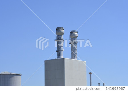 Industrial smokestacks at a power plant under blue sky Industrial smokestacks at a power plant under blue sky 141998967