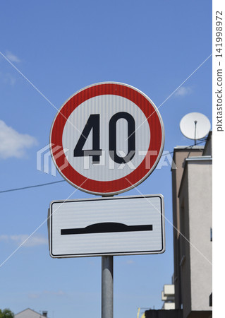 Speed limit 40 and speed bump road signs against blue sky Speed limit 40 and speed bump road signs against blue sky 141998972