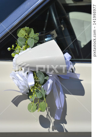 White wedding car mirror decorated with floral arrangement White wedding car mirror decorated with floral arrangement 141998977