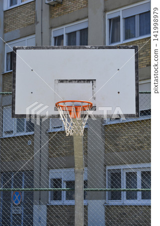 Basketball Hoop and Backboard in Front of Residential Building Basketball Hoop and Backboard in Front of Residential Building 141998979