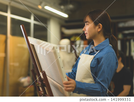 A young woman concentrating on painting A young woman concentrating on painting 141999331