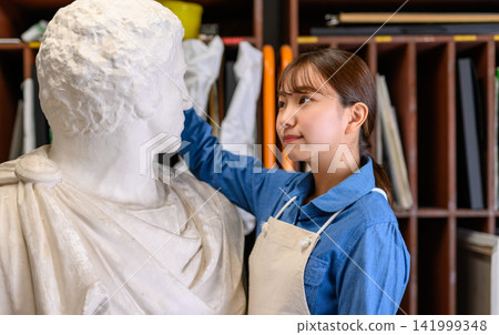 A woman gently caressing a sculpture. A woman gently caressing a sculpture. 141999348